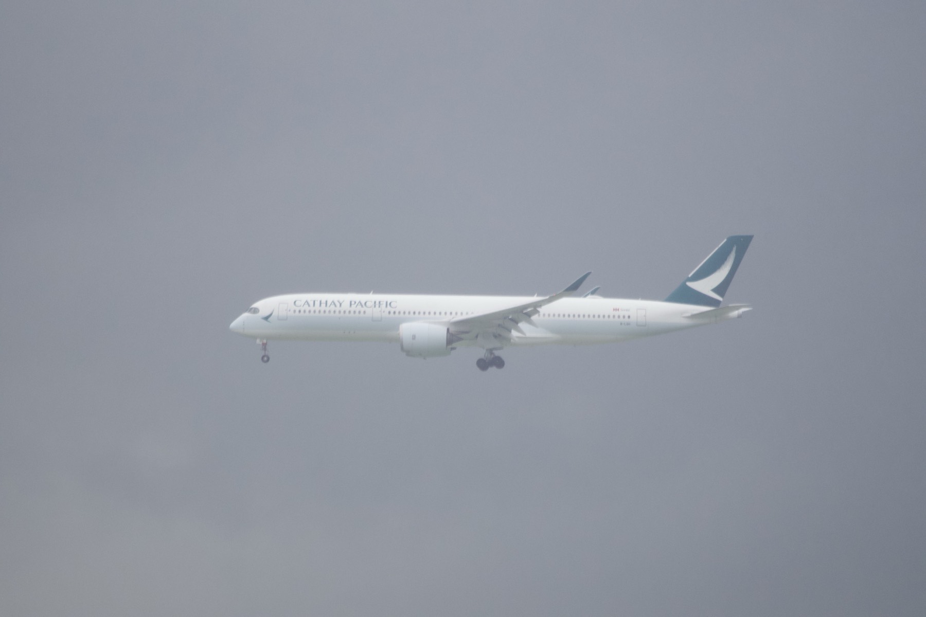 国泰 A350 在灰色天幕里放轮进近。